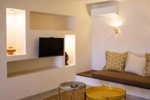 a living room with a couch and a tv at Sama Lodge in Saly Portudal