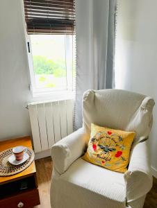 a white chair with a pillow in a room with a window at Casa Claudio Palomar in Palomar de Arroyos