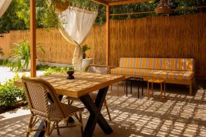 a patio with a wooden table and a couch at Sama Lodge in Saly Portudal