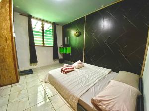 a bedroom with a bed with a black wall at DA Family Mini Garden in Ranau