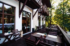 un restaurante con mesas de madera y sillas en un patio en Dwa Potoki en Karpacz