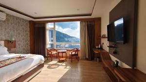 a hotel room with a bed and a table and chairs at The Z Retreat & Spa - Swimming Pool & Free Parking - Near Tashi ViewPoint in Gangtok