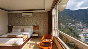 a bedroom with a bed and a large window at The Z Retreat & Spa - Swimming Pool & Free Parking - Near Tashi ViewPoint in Gangtok