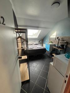 a small room with a bed and a refrigerator at Capstay - Trith Netflix in Trith-Saint-Léger