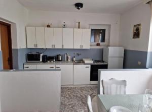 a small kitchen with white cabinets and a table with a table sidx sidx at Apartment Sea View in Karlobag