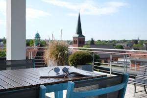 a table with a book and glasses on a balcony at HUB Apartments in Hamburg