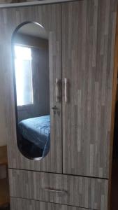a cabinet with a mirror and a bed in a room at Cuarto por candelaria 2026 in Puno