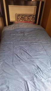 a bed with a blue blanket on top of it at Cuarto por candelaria 2026 in Puno