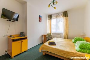a bedroom with a bed and a flat screen tv at Bursztynek in Gdynia