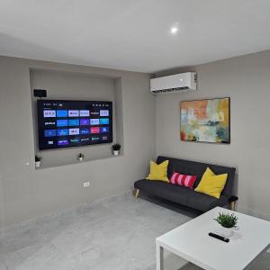 a living room with a couch and a flat screen tv at Latitude Adjustment in San Juan