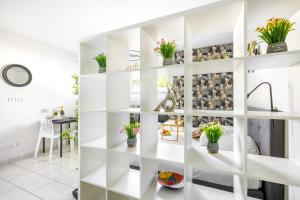 a room with white shelves with potted plants at BnGo I Le Cosy des Canuts I Parking, 2p, proche hôpital in Caluire-et-Cuire