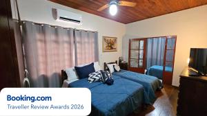 a bedroom with two beds and a television in it at Casa dos Coelhos, 750m do centro, até 12 pessoas in Tiradentes