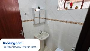 a white bathroom with a toilet and a mirror at Casa dos Coelhos, 750m do centro, até 12 pessoas in Tiradentes +79 photos