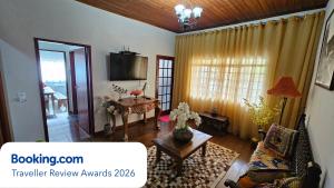 a living room with a couch and a table at Casa dos Coelhos, 750m do centro, até 12 pessoas in Tiradentes