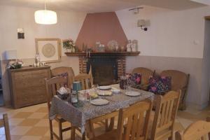 a dining room with a table and chairs and a fireplace at Pensjonat Halny Jaworzynka in Jaworzynka