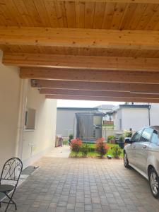 a patio with a car parked under a wooden ceiling at Ruhige Gästehaus AVOLli in Mellach