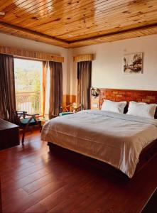 a bedroom with a large bed with a wooden ceiling at Shalom Hillcrest Inn in Shimla +59 photos