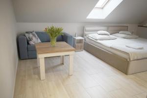 a bedroom with a bed and a table and a couch at Pensjonat Halny Jaworzynka in Jaworzynka +41 photos
