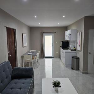a living room with a couch and a table and a kitchen at Latitude Adjustment in San Juan