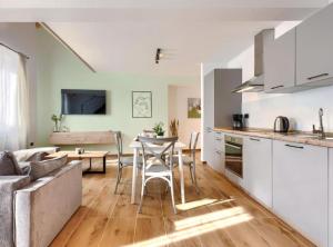 a kitchen and living room with a table and a couch at Apartments Zanet & Niccolo in Fažana