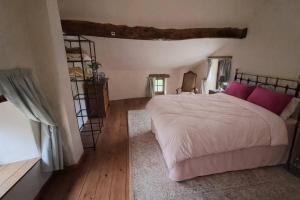 a bedroom with a large bed with pink pillows at Maison Saint Romain in Saulgond
