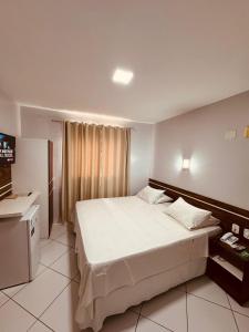 ein Schlafzimmer mit einem großen weißen Bett und einem Fernseher in der Unterkunft Schalom Hotel in Imperatriz + 52 Fotos
