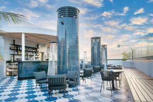 a rooftop bar with chairs and tables on a deck at Barceló Santa Cruz Contemporáneo in Santa Cruz de Tenerife