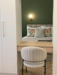 a white chair sitting in front of a desk with a bed at Atelie Home Experience 2 in Serres