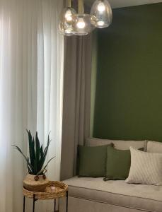 a living room with a couch and a green wall at Atelie Home Experience 2 in Serres