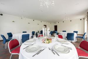 a dining room with white tables and blue chairs at BURMISTRO NAMAS in Druskininkai