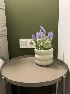 a table with a vase with purple flowers on it at Atelie Home Experience 2 in Serres +10 photos