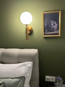 a lamp on a green wall next to a couch at Atelie Home Experience 2 in Serres