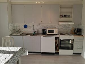 a kitchen with white cabinets and a sink and a microwave at Hus i Los in Los +5 photos