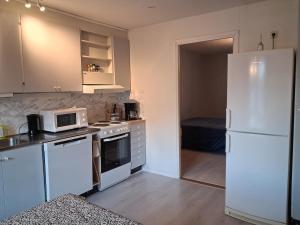 a kitchen with a white refrigerator and a microwave at Hus i Los in Los