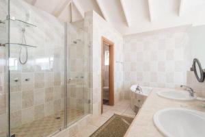 a bathroom with a shower and two sinks and a tub at Rothman's Sea View in Pacaltsdorp +23 photos