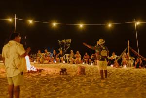 a group of people standing on a beach at night at Villa Arapiuns - 6 Bangalôs na Floresta in Santarém