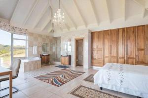 a large bedroom with a bed and a desk in it at Rothman's Sea View in Pacaltsdorp
