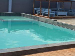 a swimming pool with blue water in a building at Eden Villas Guesthouse in Kuruman