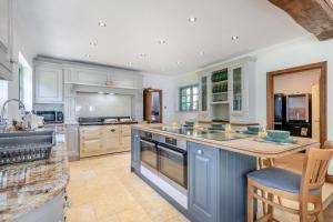 a large kitchen with white cabinets and a blue island at 7 Bed in Coltishall oc-m31936 in Coltishall
