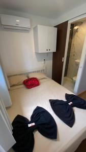 a bed in a room with two robes on it at Solar do Braz Tiny House in Florianópolis +6 photos