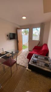a room with a bed and a table and a stove at Solar do Braz Tiny House in Florianópolis