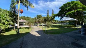 a path in a park with palm trees and a pavilion at Solar do Braz Tiny House in Florianópolis