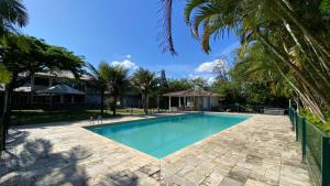 a swimming pool in a yard with palm trees at Solar do Braz Tiny House in Florianópolis