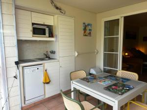 a small kitchen with a table and a microwave at Studio Saint Vincent 13 Non PMR in Sainte-Luce