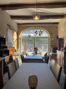 a dining room with a long table and chairs at L'Entre-Coeur in Ménétru-le-Vignoble