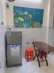 a room with a table and a fish mural on the wall at Homestay Hưởng Thụ - Nhơn Lý in Quy Nhon +12 photos