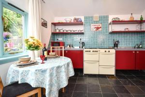 a kitchen with red cabinets and a table with a table cloth at 1 Bed in Wadebridge oc-p00223 in Little Petherick