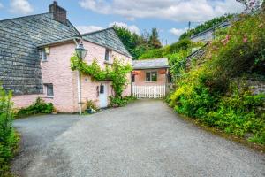 a stone driveway leading to a pink house at 1 Bed in Wadebridge oc-p00223 in Little Petherick
