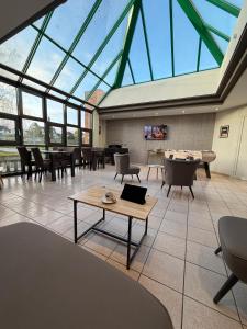 a room with a large glass ceiling with a pool table at Cit'Hotel LA PYRAMIDE in Romorantin