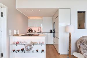 a kitchen with white cabinets and a table at Sea View Suite in Scharbeutz +8 photos